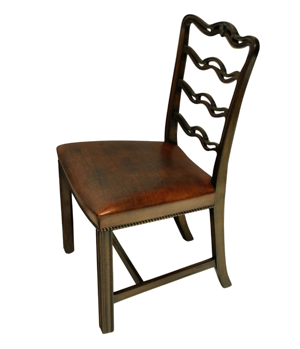 A set of six dark mahogany George III style ladderback dining chairs with brass-studded brown leather seats. View VI