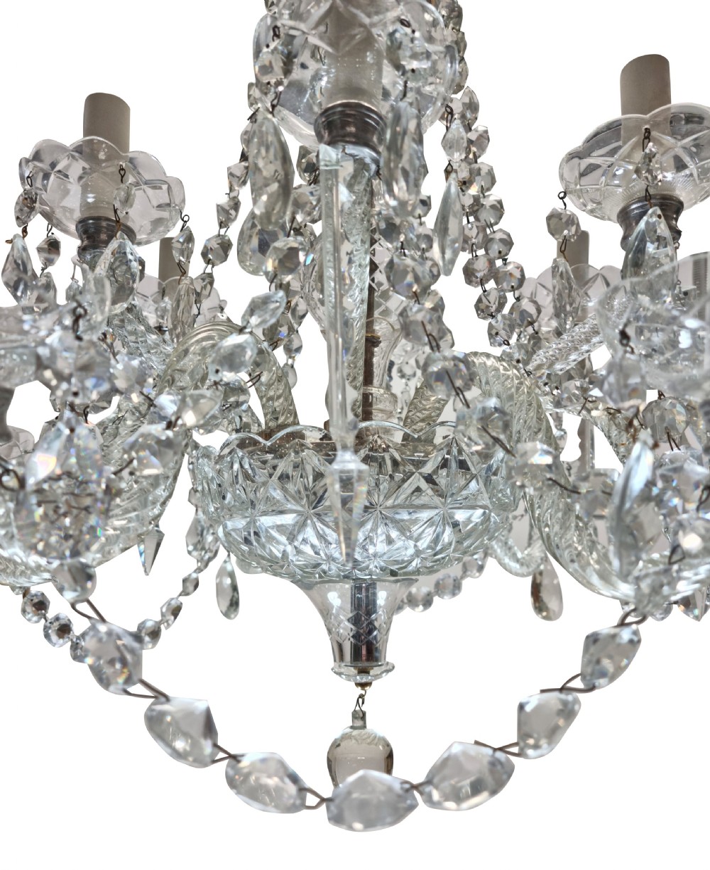 An English twelve-light cut glass chandelier featuring tiered glass arms, faceted crystal drops, and cascading bead swags. View III