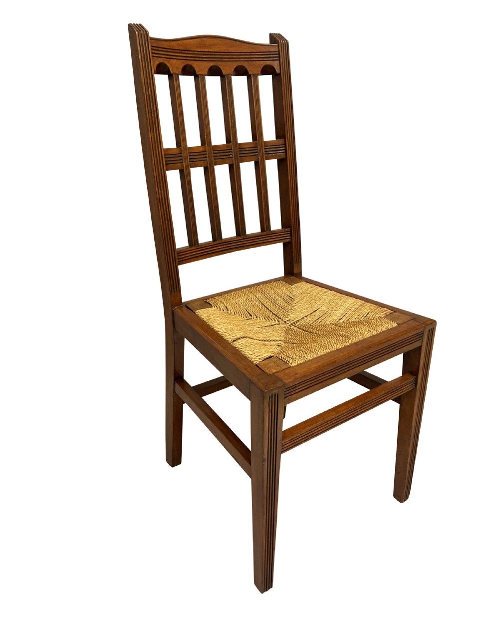 A set of four English Aesthetic Movement mahogany dining chairs featuring vertical spindle backs and natural rush woven seats. View III