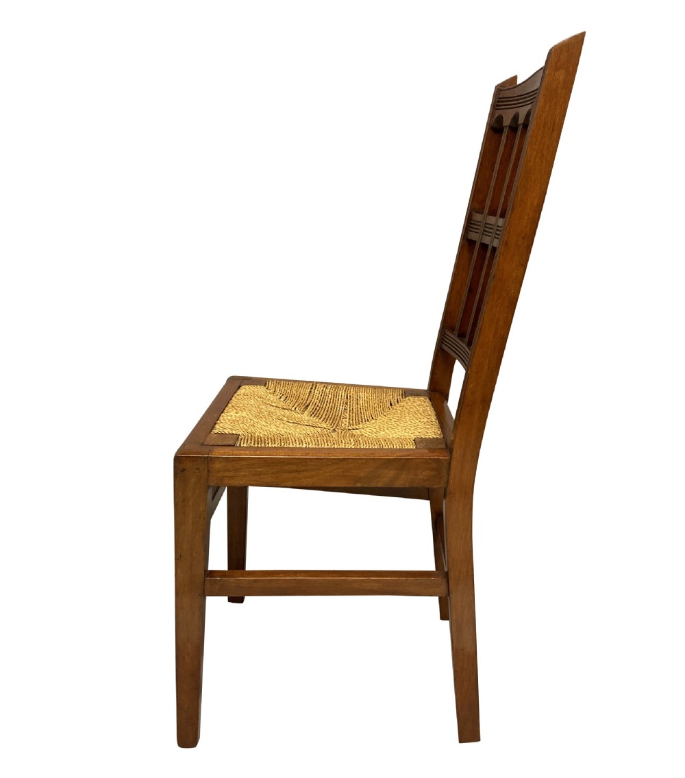 A set of four English Aesthetic Movement mahogany dining chairs featuring vertical spindle backs and natural rush woven seats. View VII