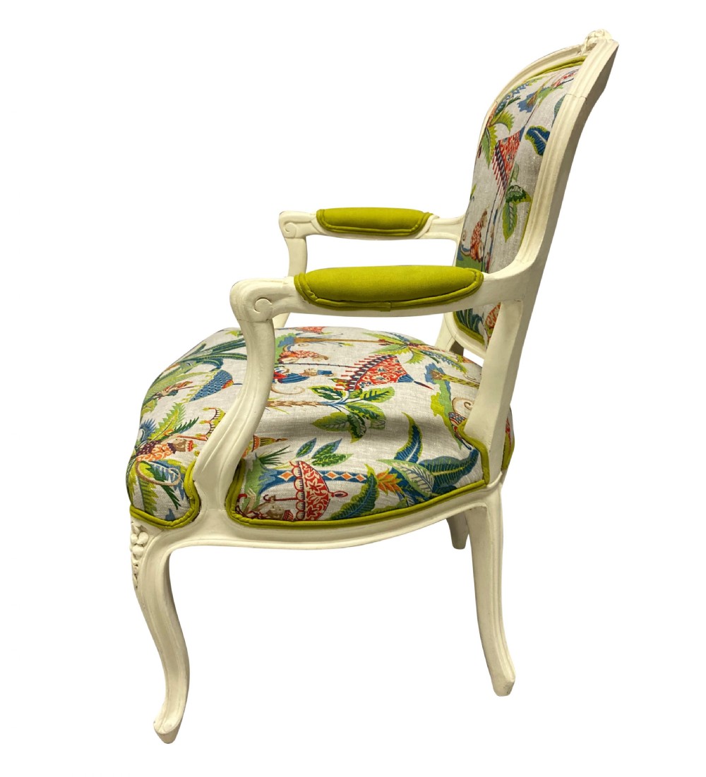 A pair of cream painted Louis XV style armchairs featuring carved cresting, cabriole legs, and upholstery with a monkey and palm tree pattern. View III