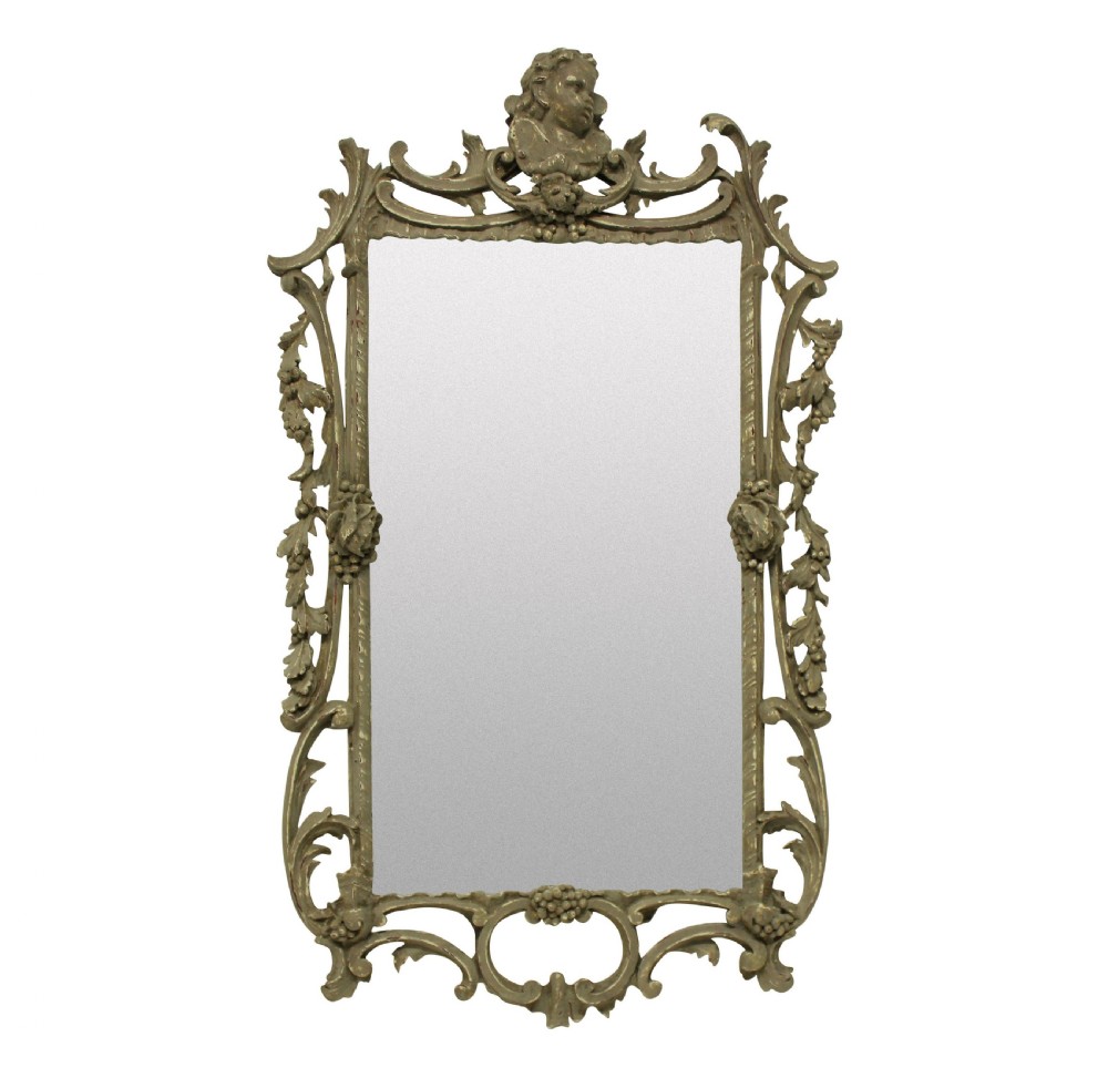 An ornate George III style rectangular wall mirror with a carved giltwood frame featuring a cherub crest, pierced acanthus scrolls, and grapevine motifs.