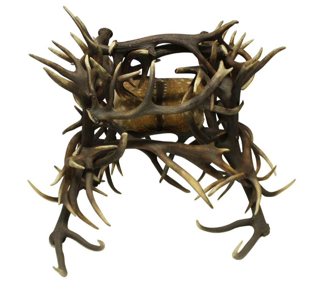 A pair of antique armchairs constructed from interwoven stag antlers with natural spotted hide seats. View II