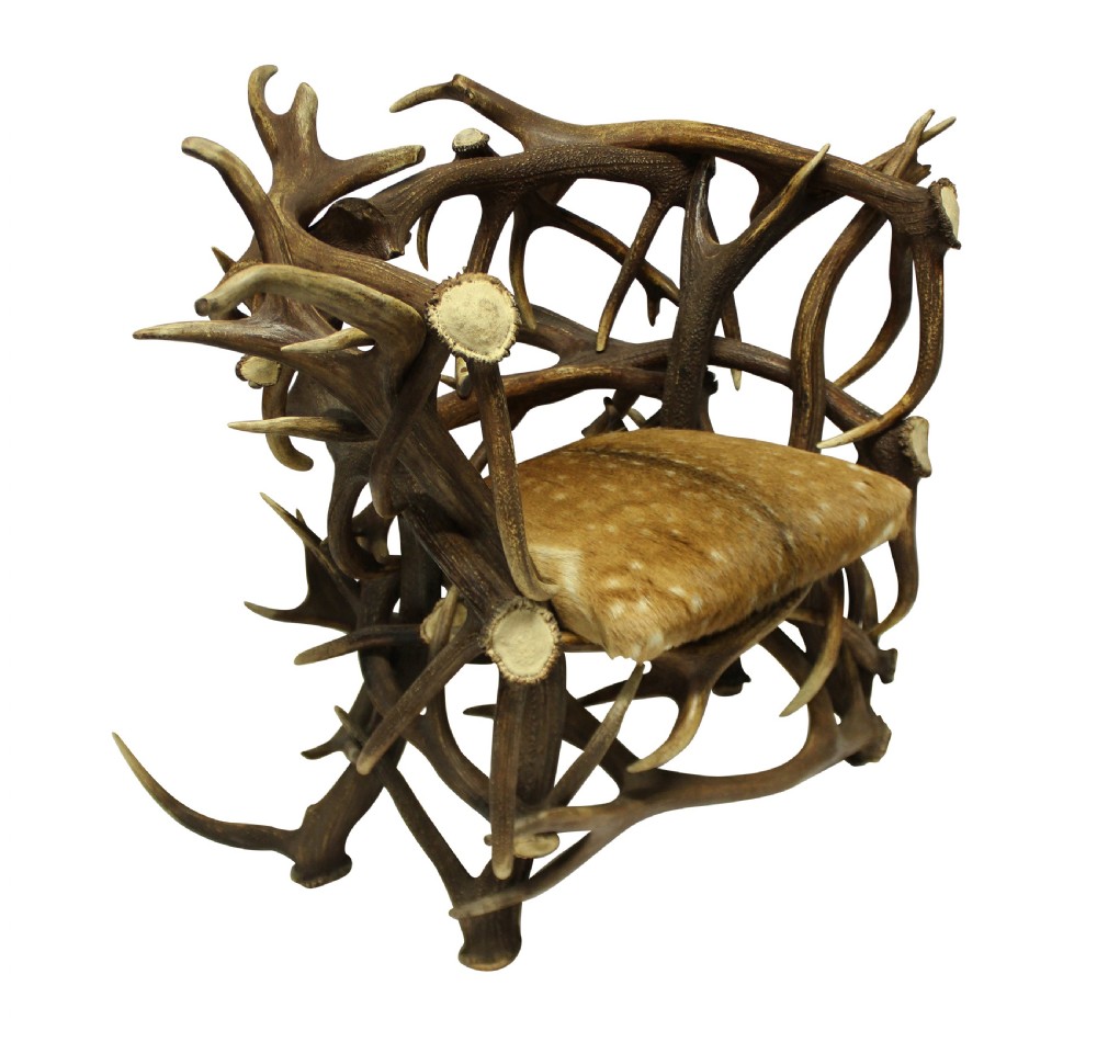 A pair of antique armchairs constructed from interwoven stag antlers with natural spotted hide seats. View IV