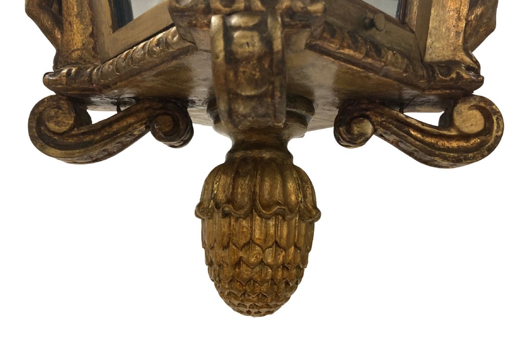 A carved Florentine giltwood hanging lantern with glazed glass panels, flanked by sculpted figures and capped with a domed top and pinecone drop. View III