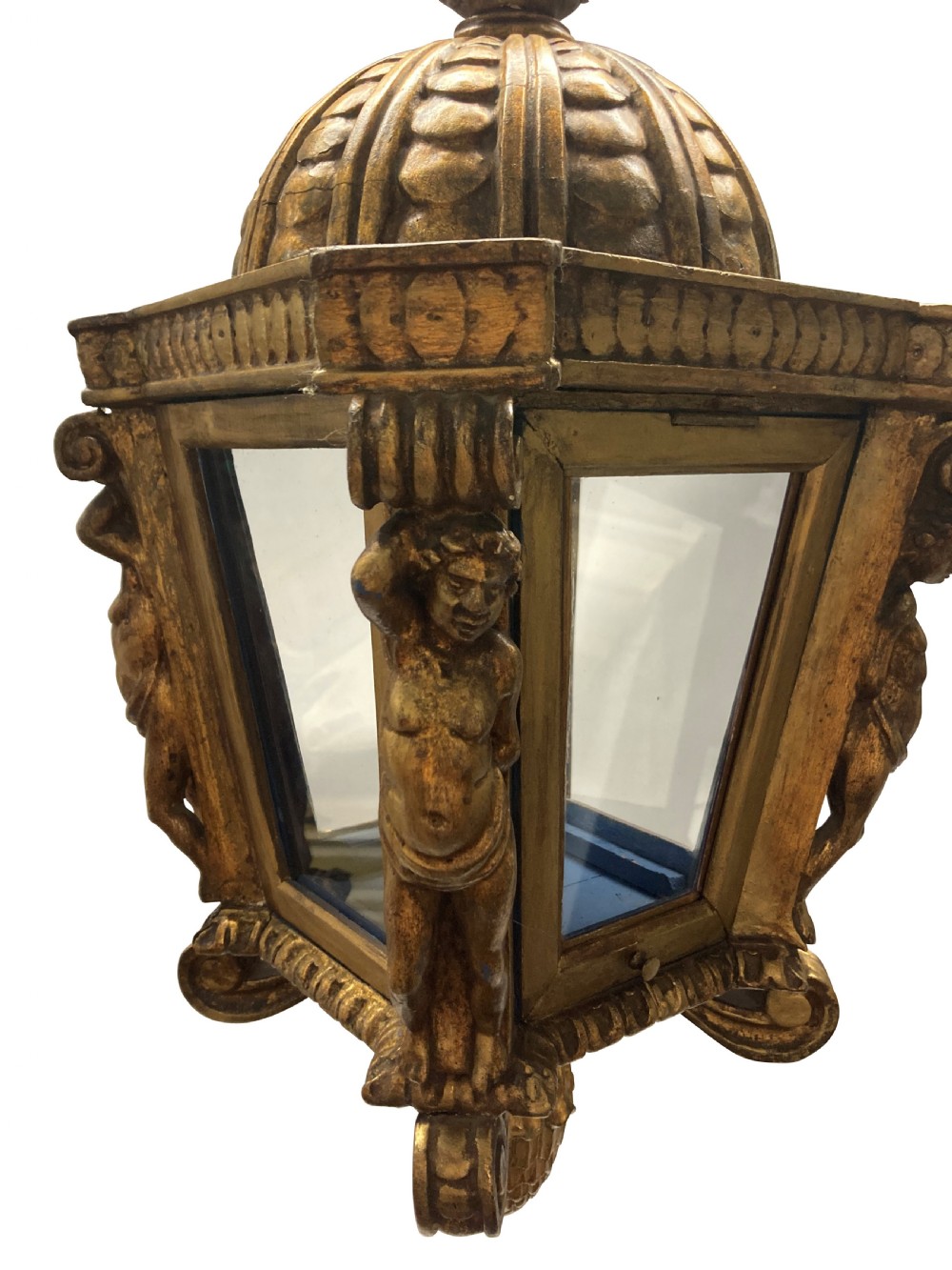 A carved Florentine giltwood hanging lantern with glazed glass panels, flanked by sculpted figures and capped with a domed top and pinecone drop. View IV