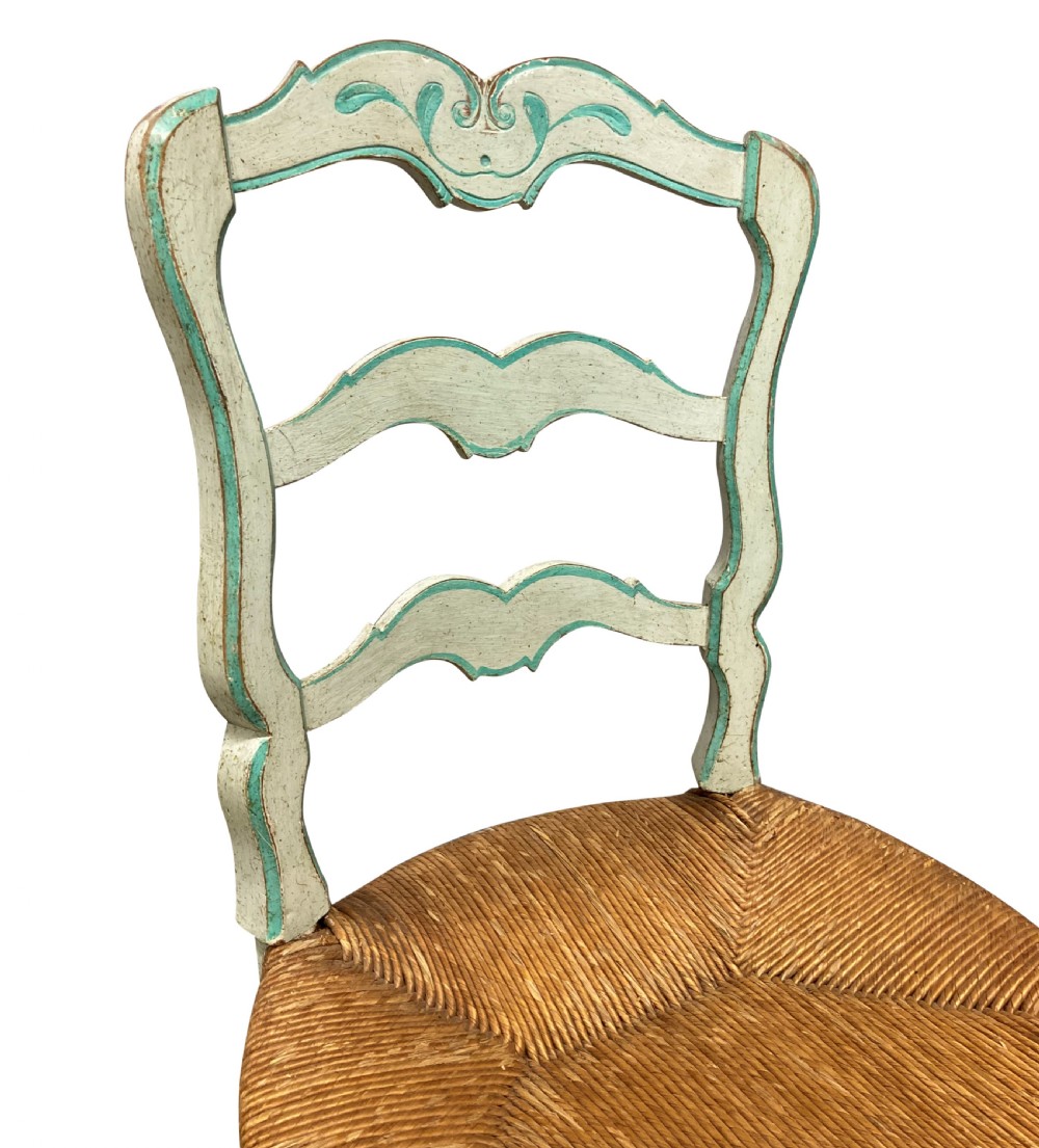 A set of four pale green painted Swedish dining chairs featuring carved wavy ladder backs, woven rush seats, and cabriole legs. View VII