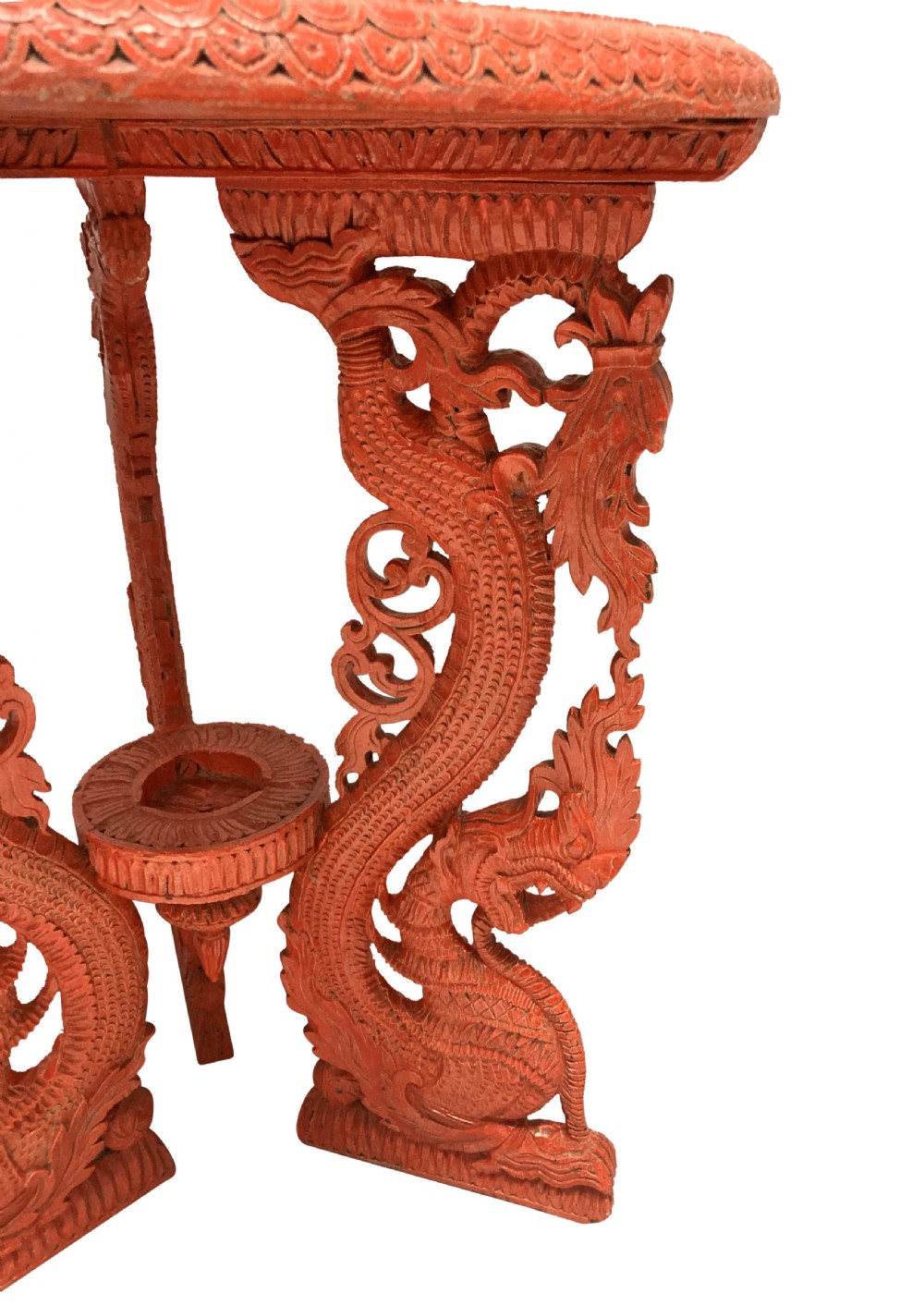 A circular red Chinese side table featuring carved cinnabar lacquered relief patterns on the top and three legs shaped as dragons. View II
