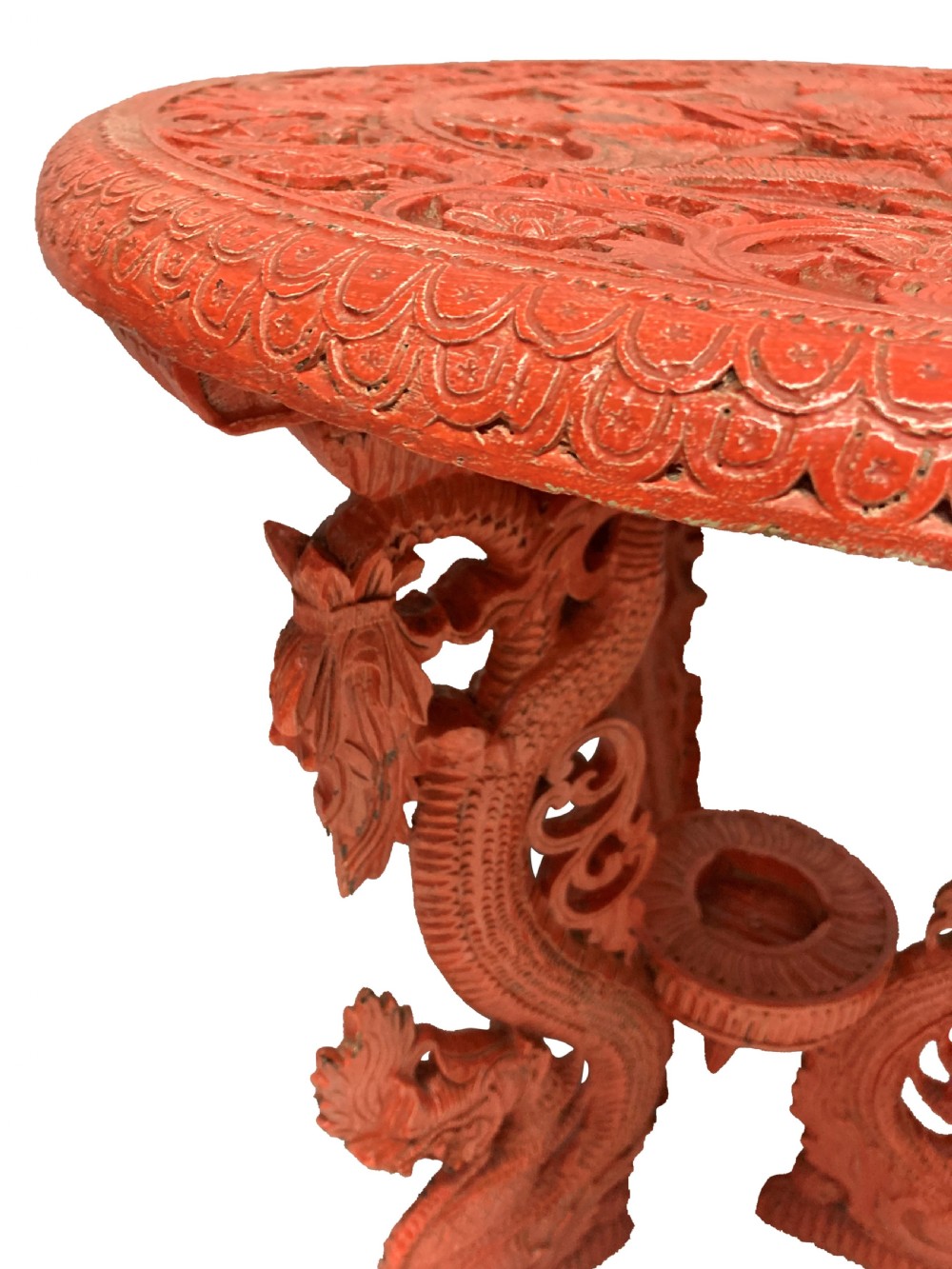 A circular red Chinese side table featuring carved cinnabar lacquered relief patterns on the top and three legs shaped as dragons. View III