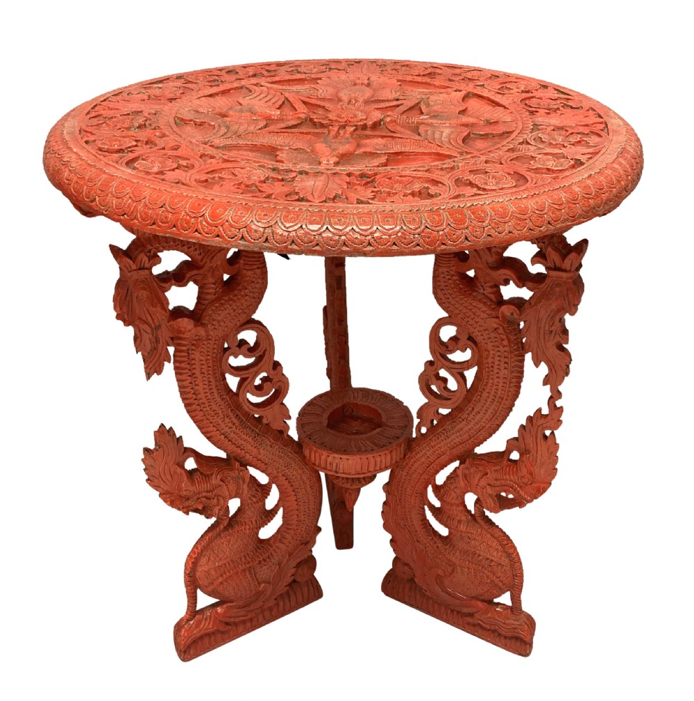 A circular red Chinese side table featuring carved cinnabar lacquered relief patterns on the top and three legs shaped as dragons. View VI