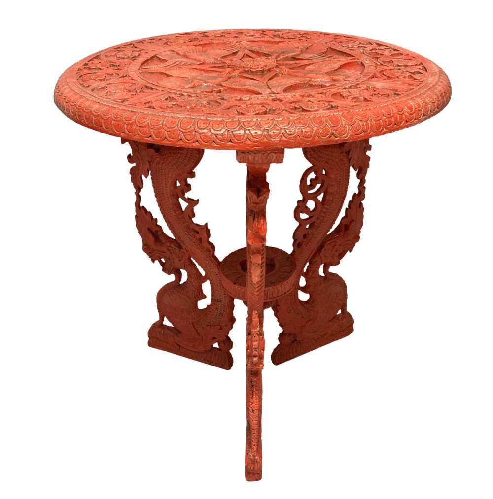 A circular red Chinese side table featuring carved cinnabar lacquered relief patterns on the top and three legs shaped as dragons. View VII