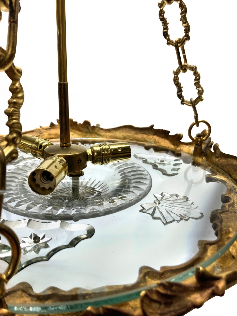 A French Rococo style light fixture featuring a gold-toned ormolu frame with scrolling foliate designs surrounding a central cut-glass bowl suspended by three decorative metal chains. View III
