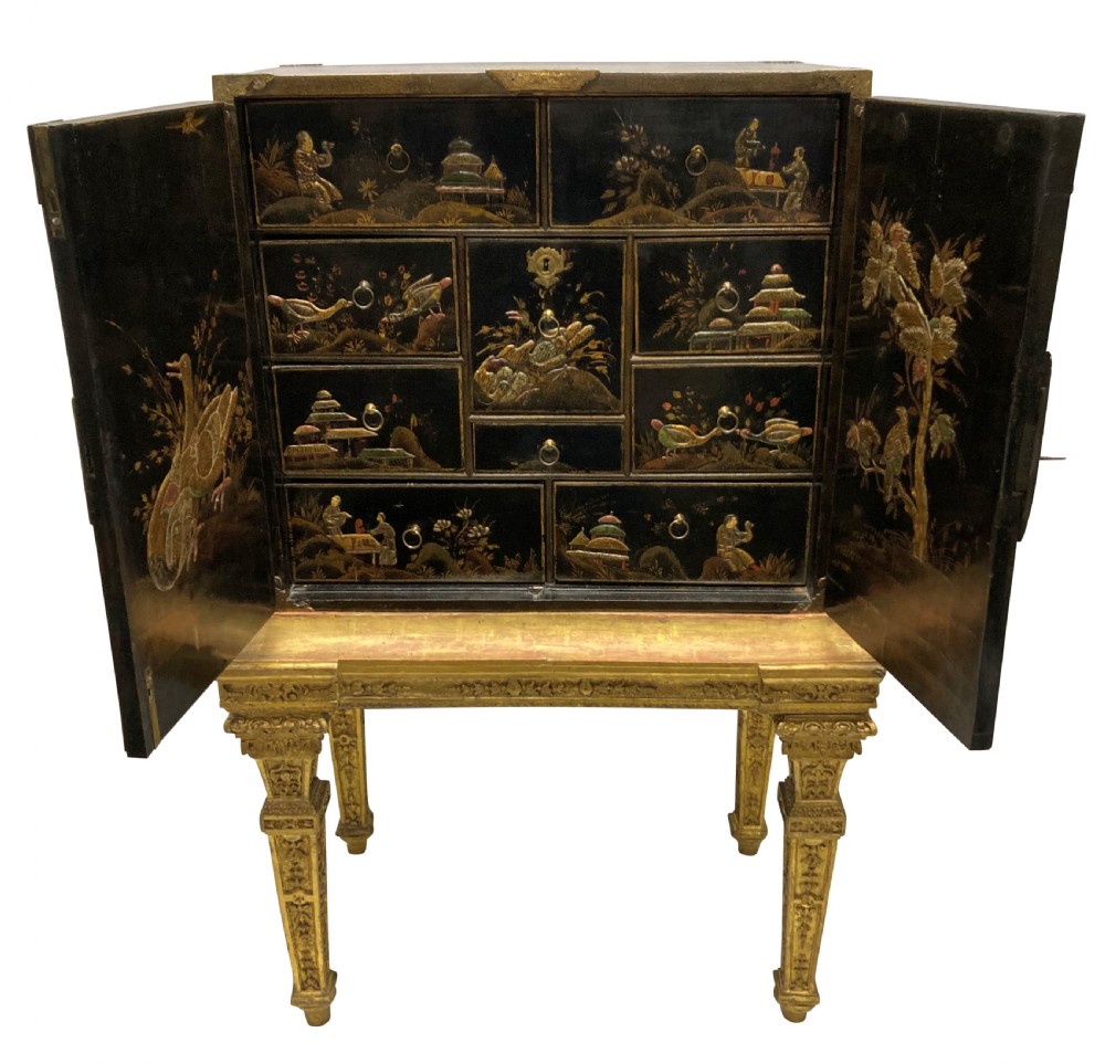 A two-door black japanned cabinet decorated with gold Chinoiserie scenes resting on a carved gilded wooden stand. View III