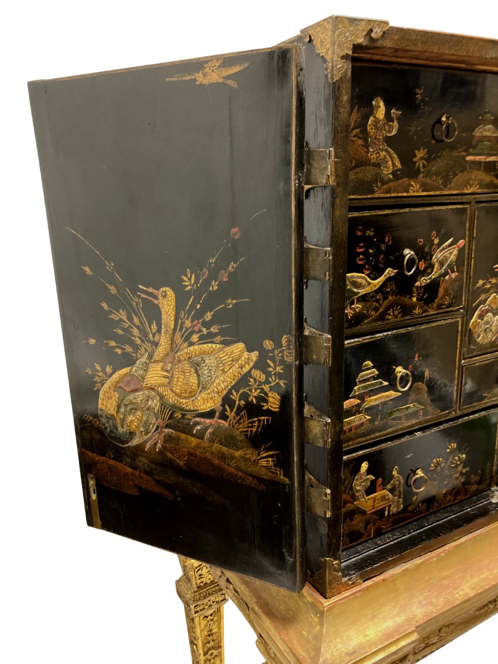 A two-door black japanned cabinet decorated with gold Chinoiserie scenes resting on a carved gilded wooden stand. View XI