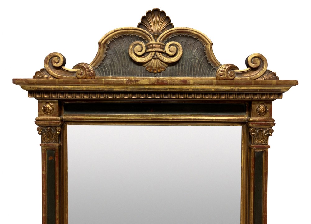 An Italian Renaissance giltwood tabernacle wall mirror featuring carved side pilasters, dark painted panels, and a cresting pediment with a central shell motif. View II