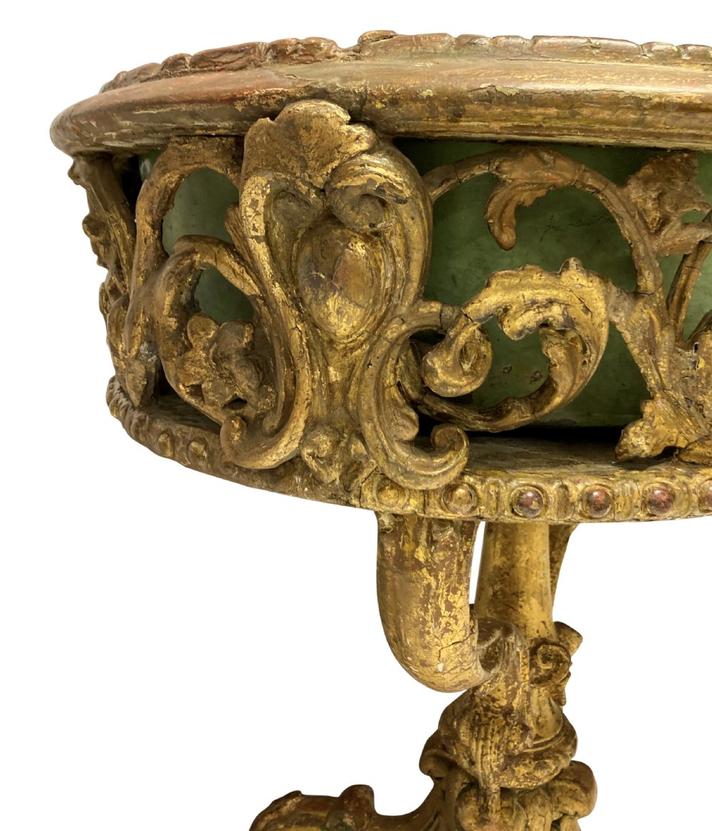 An early 19th-century carved giltwood circular jardiniere featuring scrollwork moulding, a green painted metal liner, and a sculpted tripod base. View III