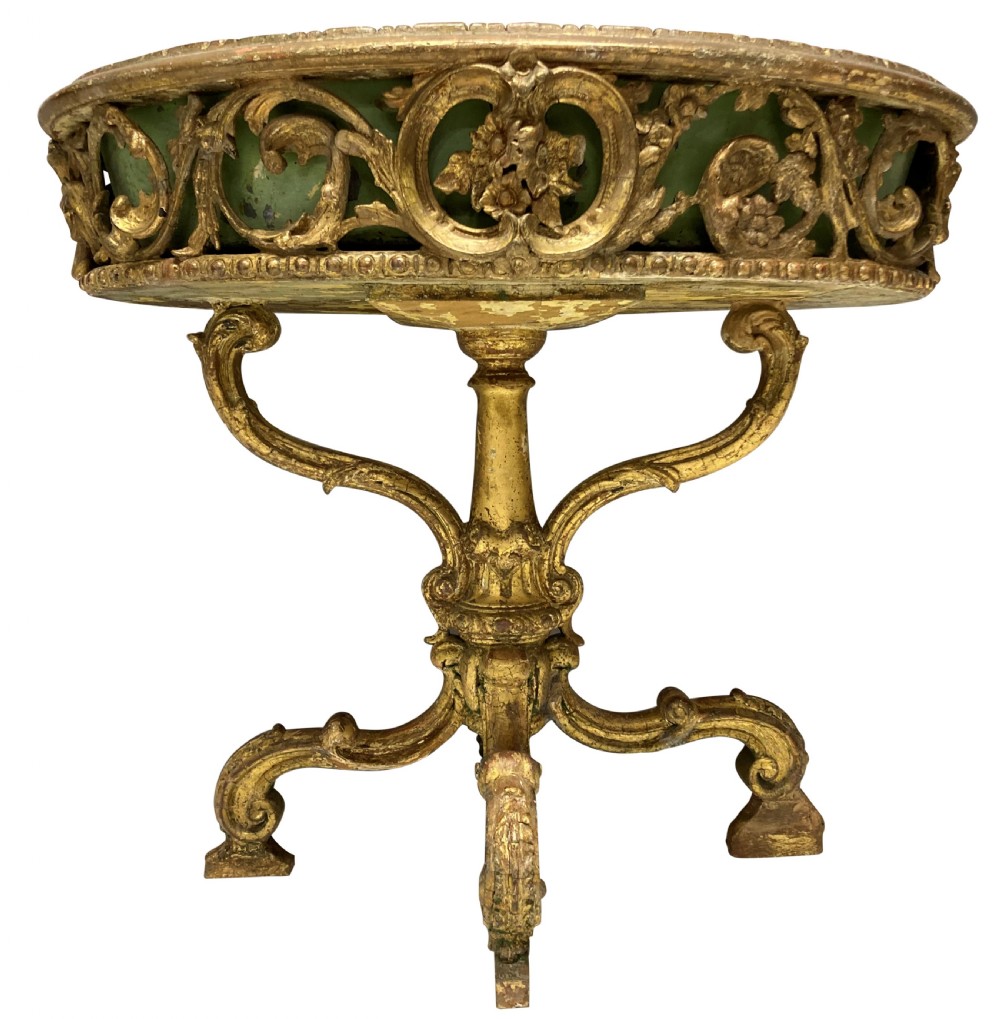An early 19th-century carved giltwood circular jardiniere featuring scrollwork moulding, a green painted metal liner, and a sculpted tripod base. View VII