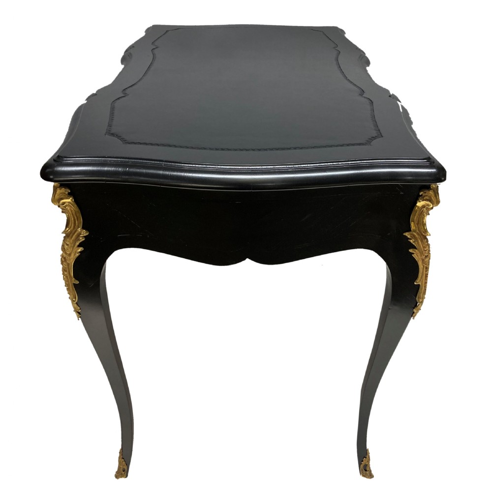A Louis XV style black lacquered writing table with cabriole legs, an inset leather surface, and ornate gilt bronze corner mounts. View III