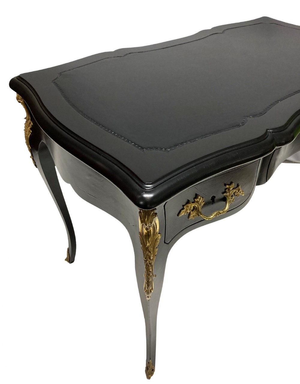 A Louis XV style black lacquered writing table with cabriole legs, an inset leather surface, and ornate gilt bronze corner mounts. View VIII