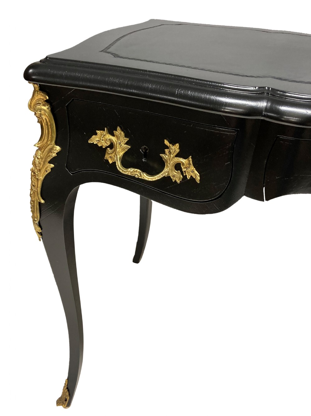 A Louis XV style black lacquered writing table with cabriole legs, an inset leather surface, and ornate gilt bronze corner mounts. View IX