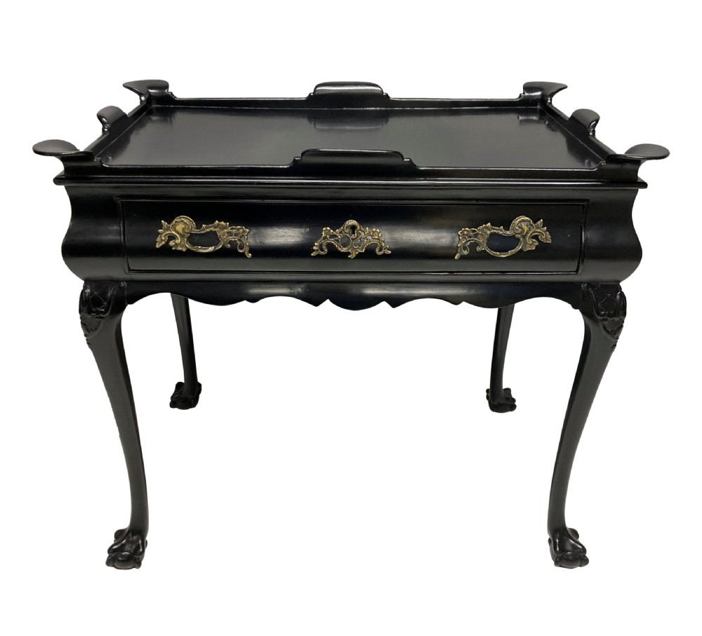 A black lacquered walnut silver table featuring a raised gallery top, a single drawer with brass handles, and cabriole legs with claw and ball feet.