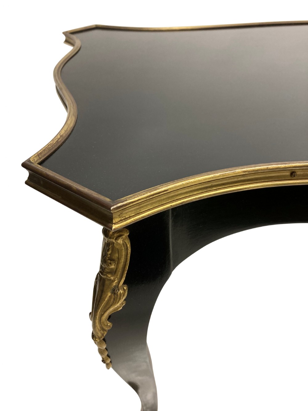 A low black lacquered Louis XV style occasional table with serpentine edges, gilt metal moulding, and cabriole legs with ormolu mounts. View VI