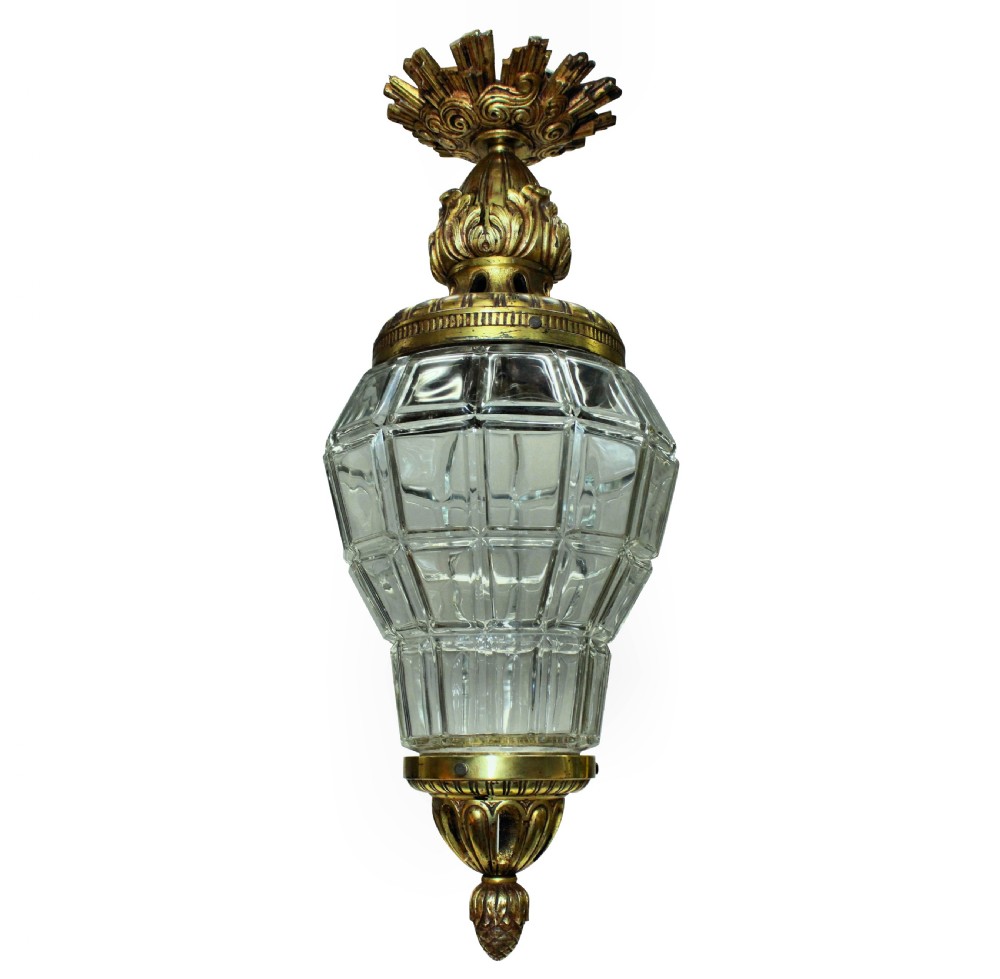 A French style gilt bronze and faceted clear glass hanging pendant lantern featuring leaf mounts and a crown canopy.