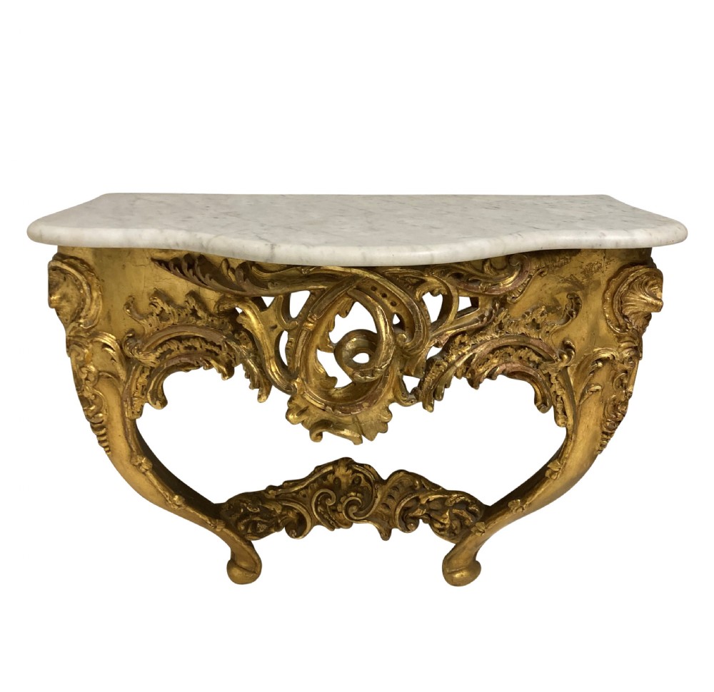 A 19th-century German Rococo Revival carved giltwood console table featuring an openwork scrolled apron and a serpentine white marble top.