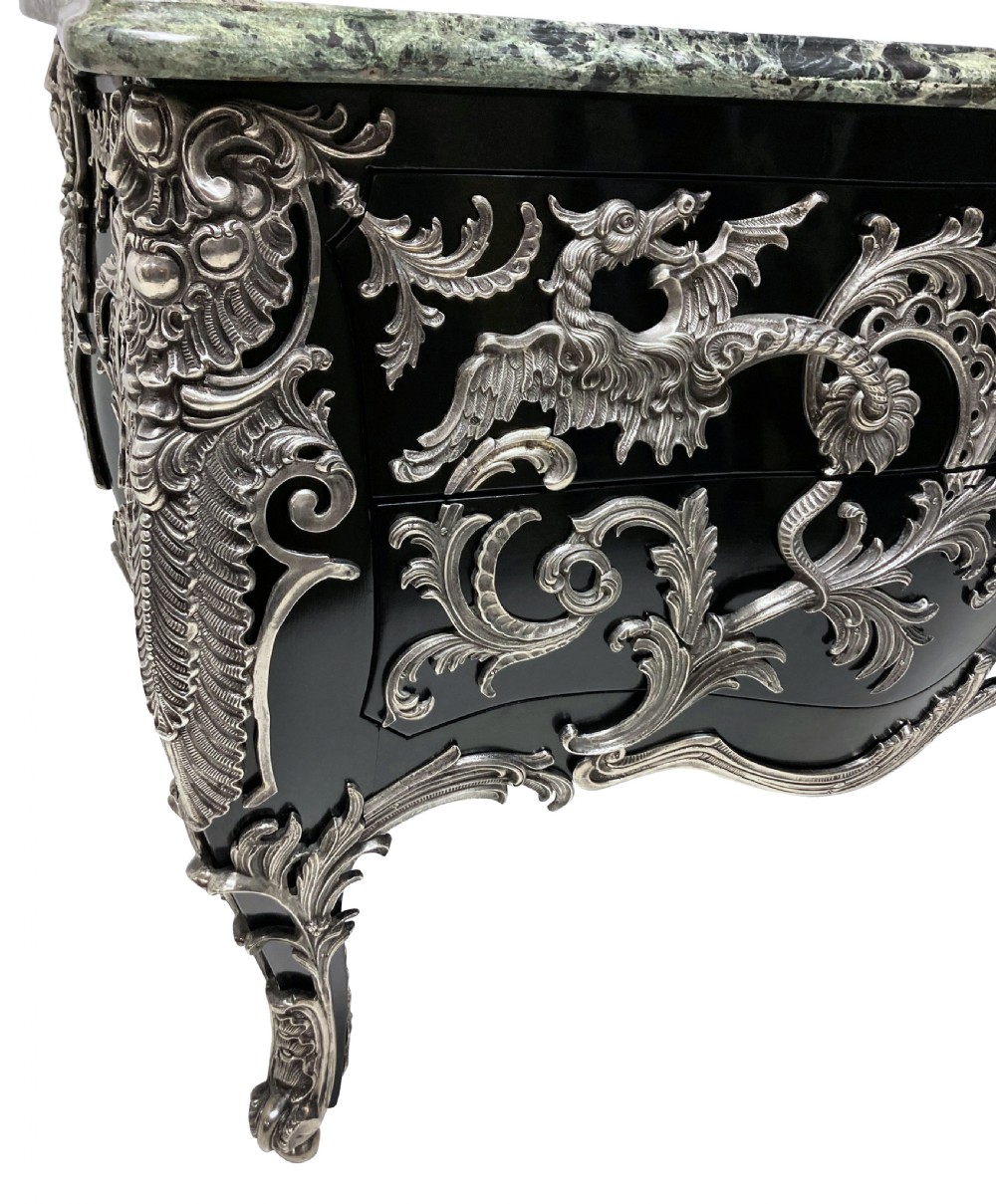 A French Rococo style black lacquered commode featuring a green marble top and elaborate silver-coloured ornamental mounts. View IX