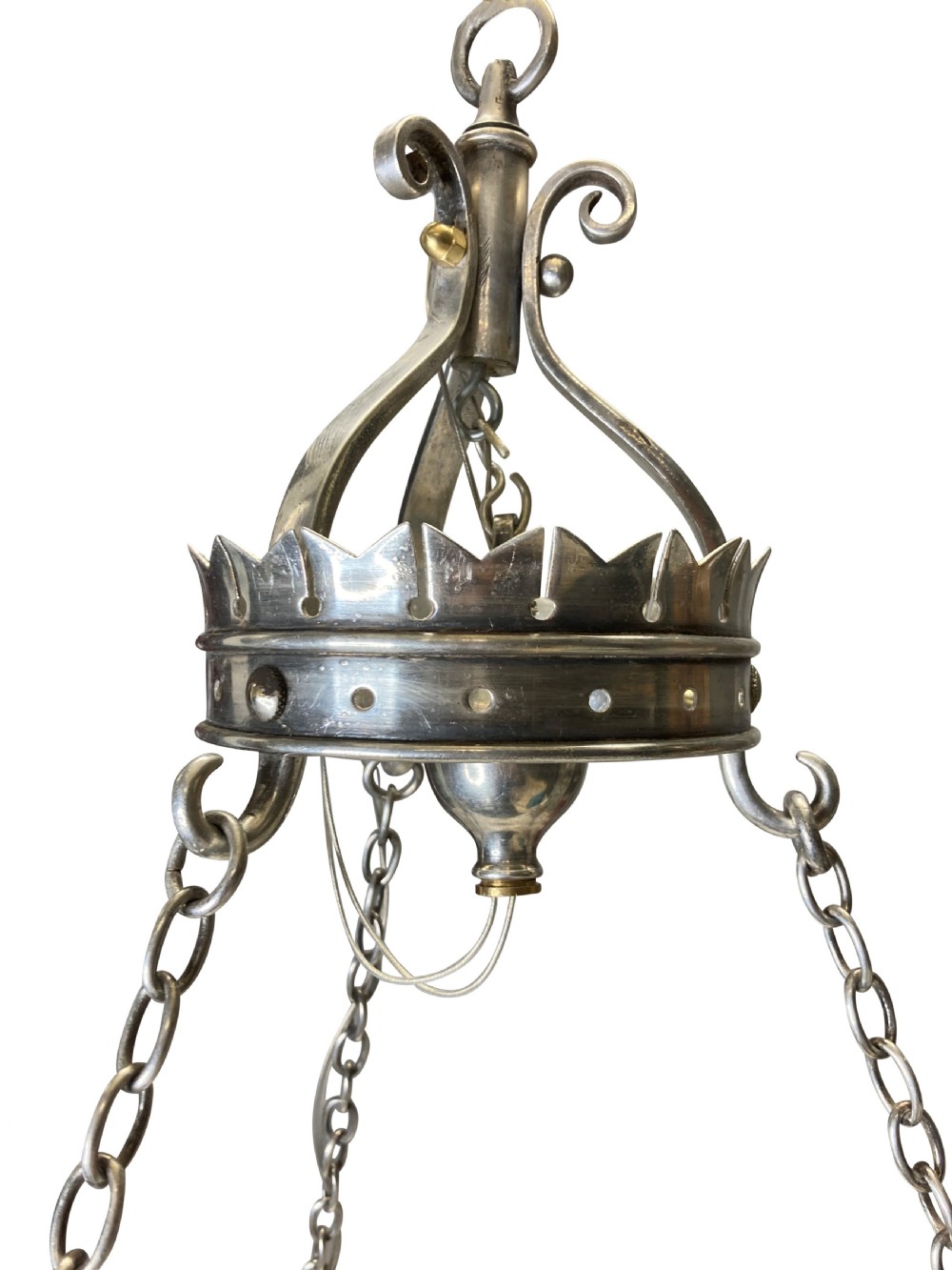 A circular silver-plated Gothic corona light fixture featuring a castellated upper rim, multiple candle-style light holders, and suspension chains leading to a crown-shaped ceiling rose. View V