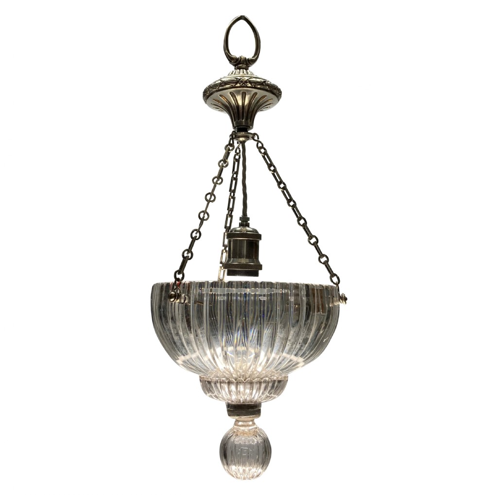 An Edwardian pendant light featuring a fluted clear cut glass bowl suspended by three silver-plated chains from a cast ceiling fitting.