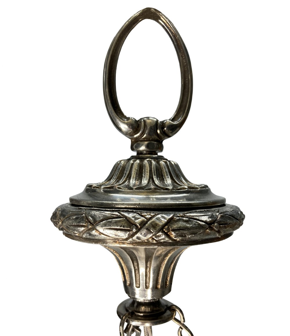 An Edwardian pendant light featuring a fluted clear cut glass bowl suspended by three silver-plated chains from a cast ceiling fitting. View V
