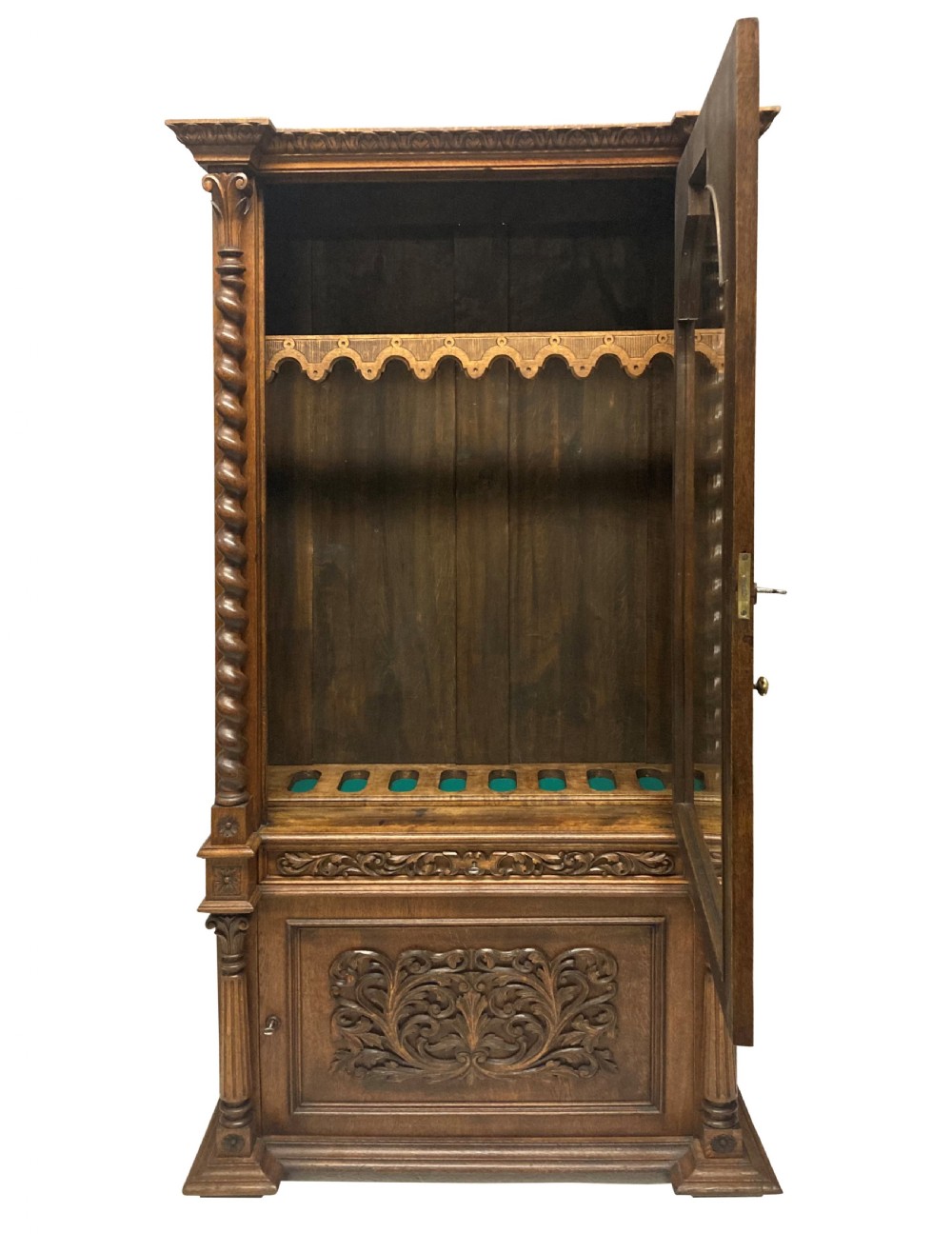 A nineteenth-century carved oak gun cabinet featuring spiralled barley twist columns, a glazed upper door, and relief-carved botanical motifs on the lower door. View IX