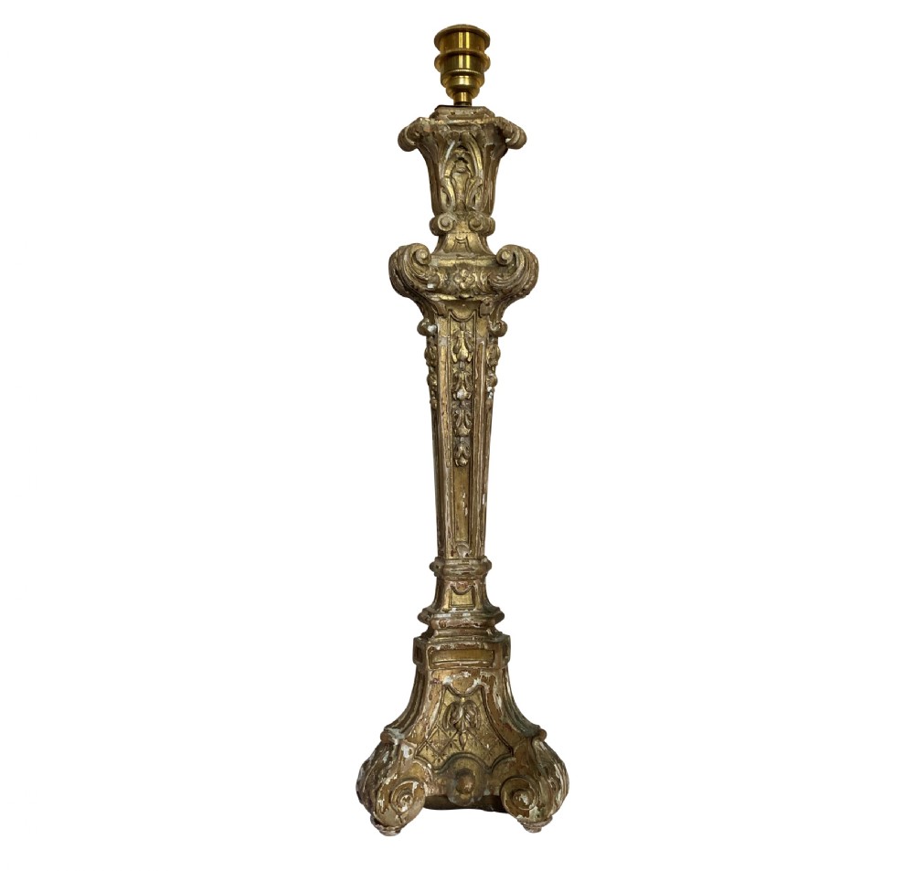 A tall English Baroque style carved giltwood table lamp base featuring elaborate scrollwork and a brass electrical socket.