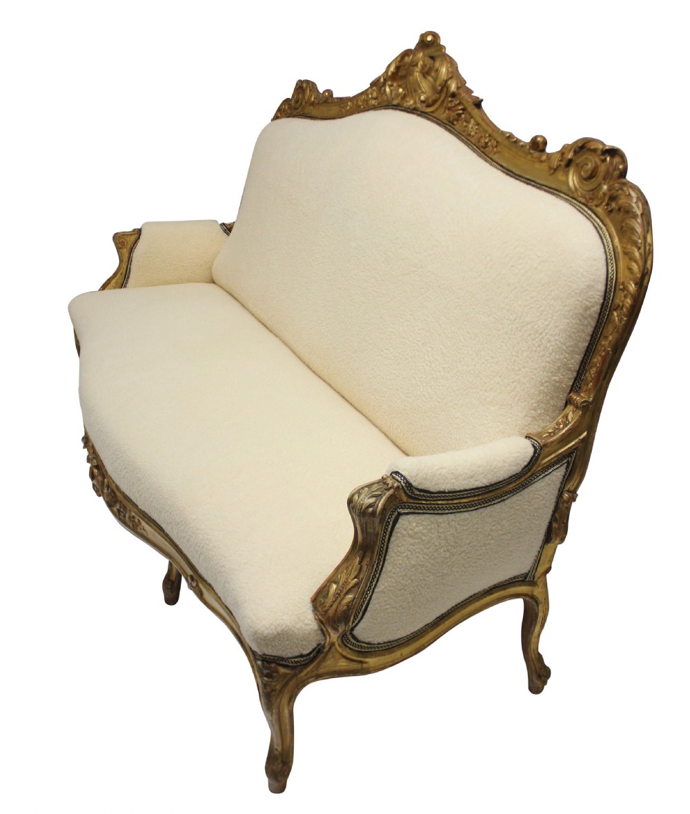 An early nineteenth-century giltwood settee featuring a carved cresting rail, cabriole legs, and cream upholstery. View II