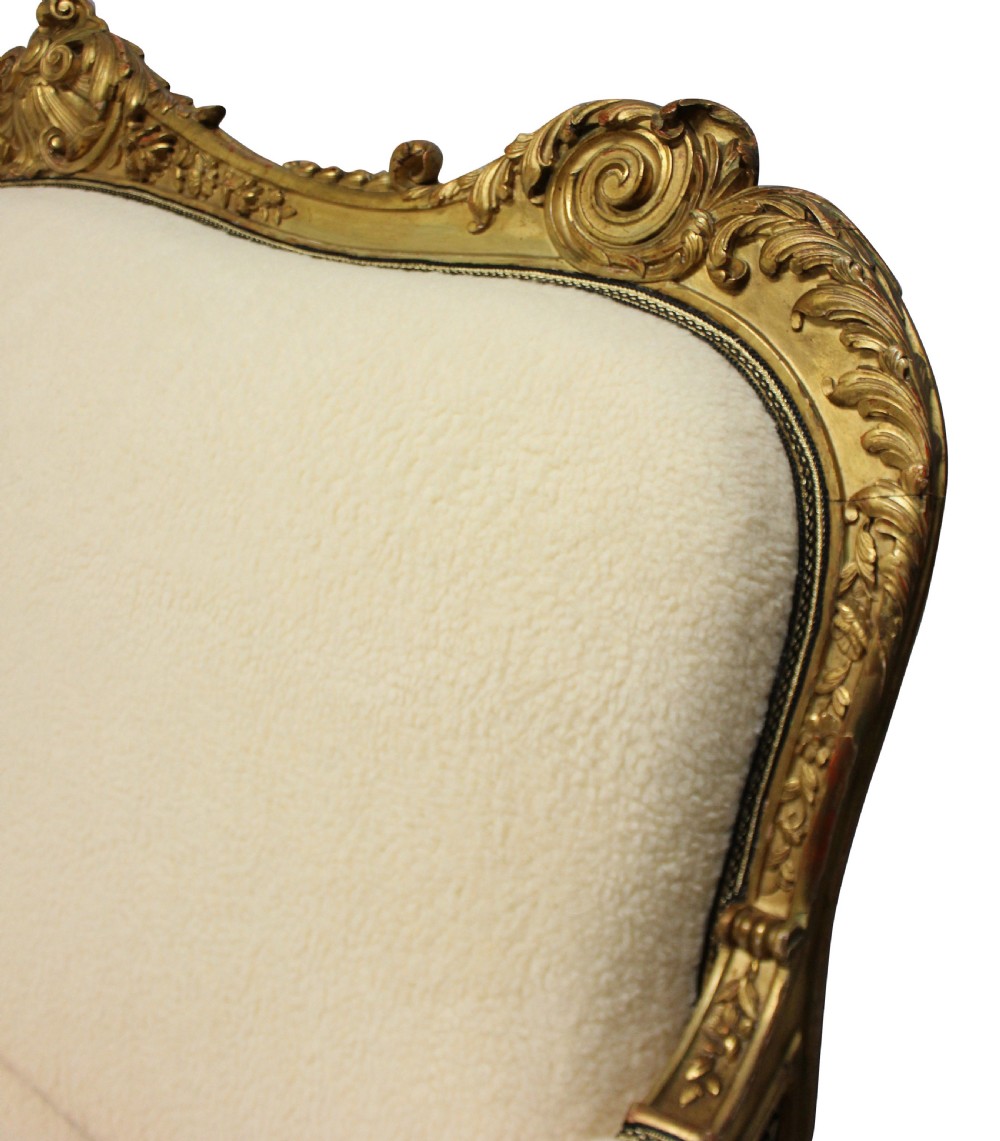 An early nineteenth-century giltwood settee featuring a carved cresting rail, cabriole legs, and cream upholstery. View III