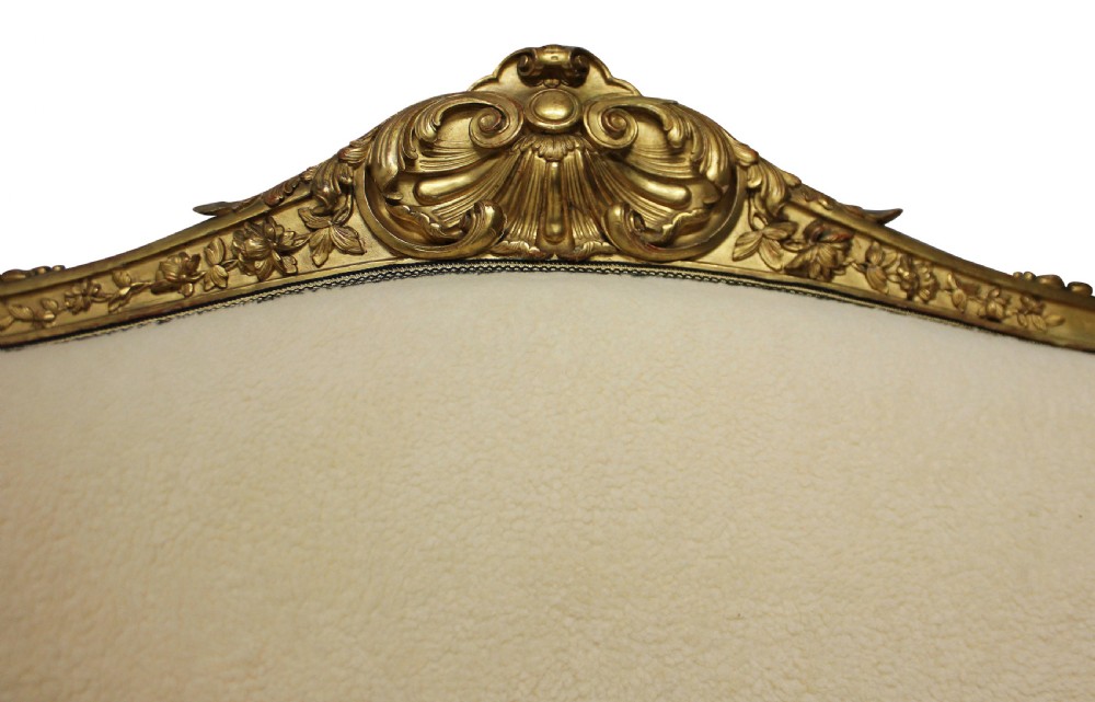 An early nineteenth-century giltwood settee featuring a carved cresting rail, cabriole legs, and cream upholstery. View IV