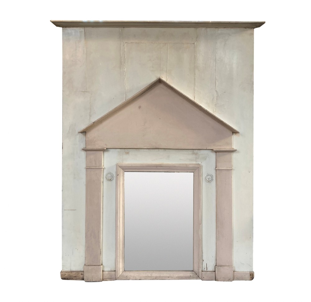 An 18th-century architectural trumeau mirror featuring a painted off-white frame with a triangular pediment, flanking pilasters, and a rectangular mirrored panel.