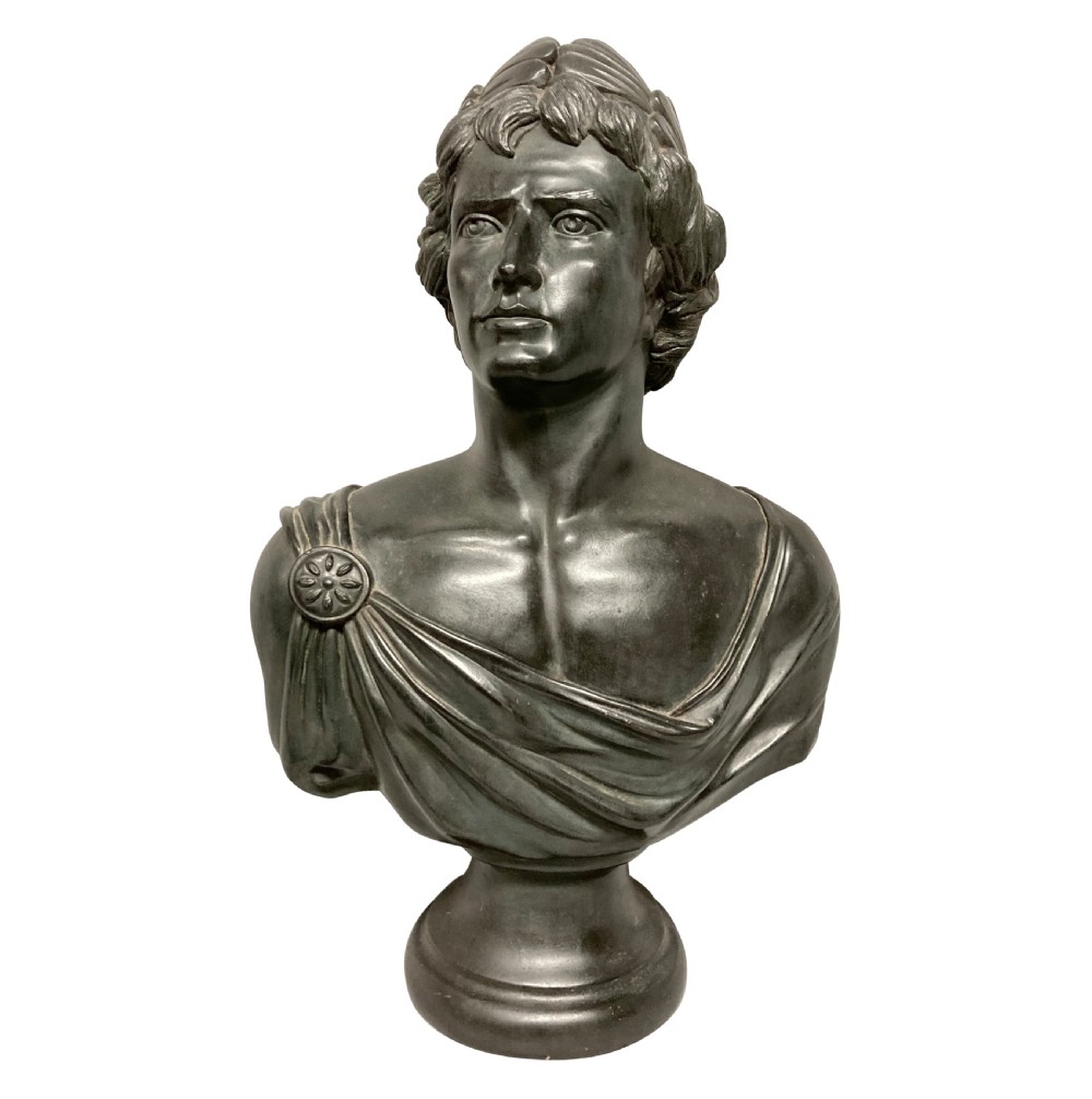 A dark bronzed plaster library bust depicting the Emperor Augustus draped in Roman robes and mounted on a rounded socle base.