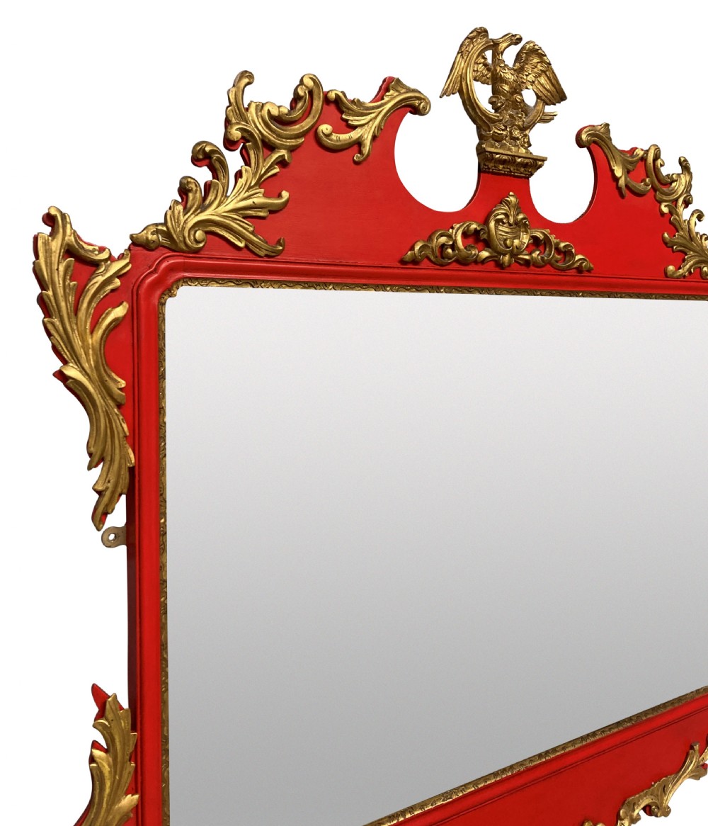 A George II style horizontal wall mirror featuring a scarlet red lacquered frame adorned with intricate giltwood rococo scrollwork and a central eagle crest. View II