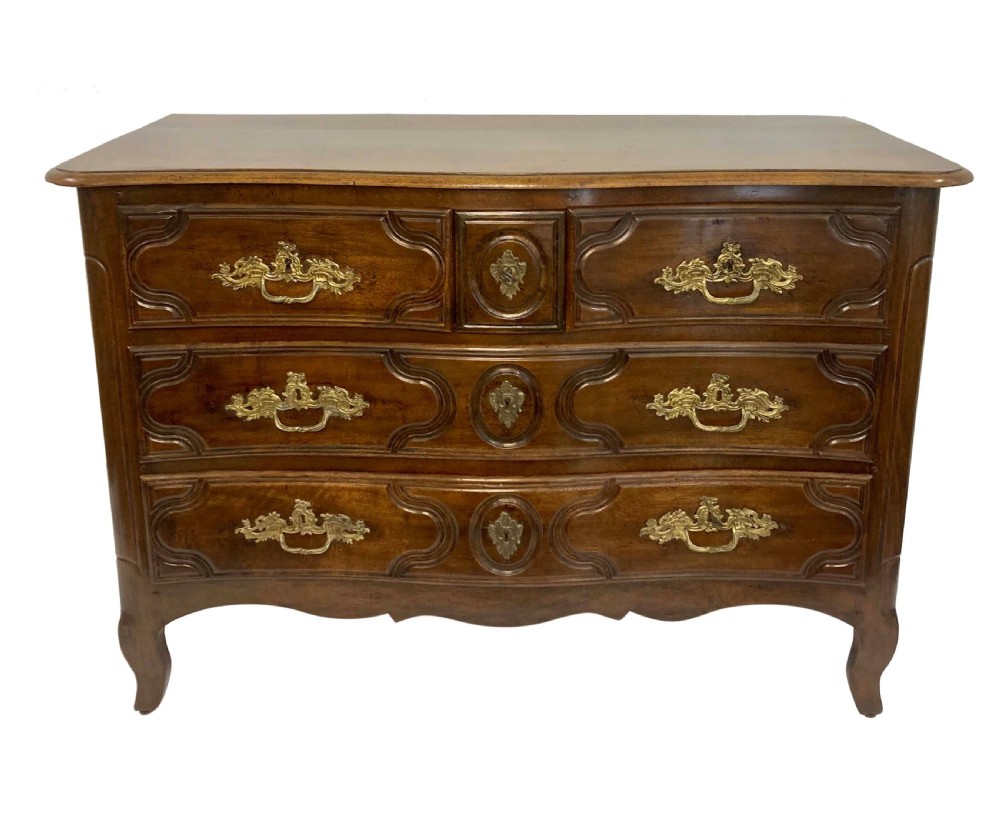 A French provincial walnut commode featuring three carved drawers with rococo brass handles and short cabriole legs. View II