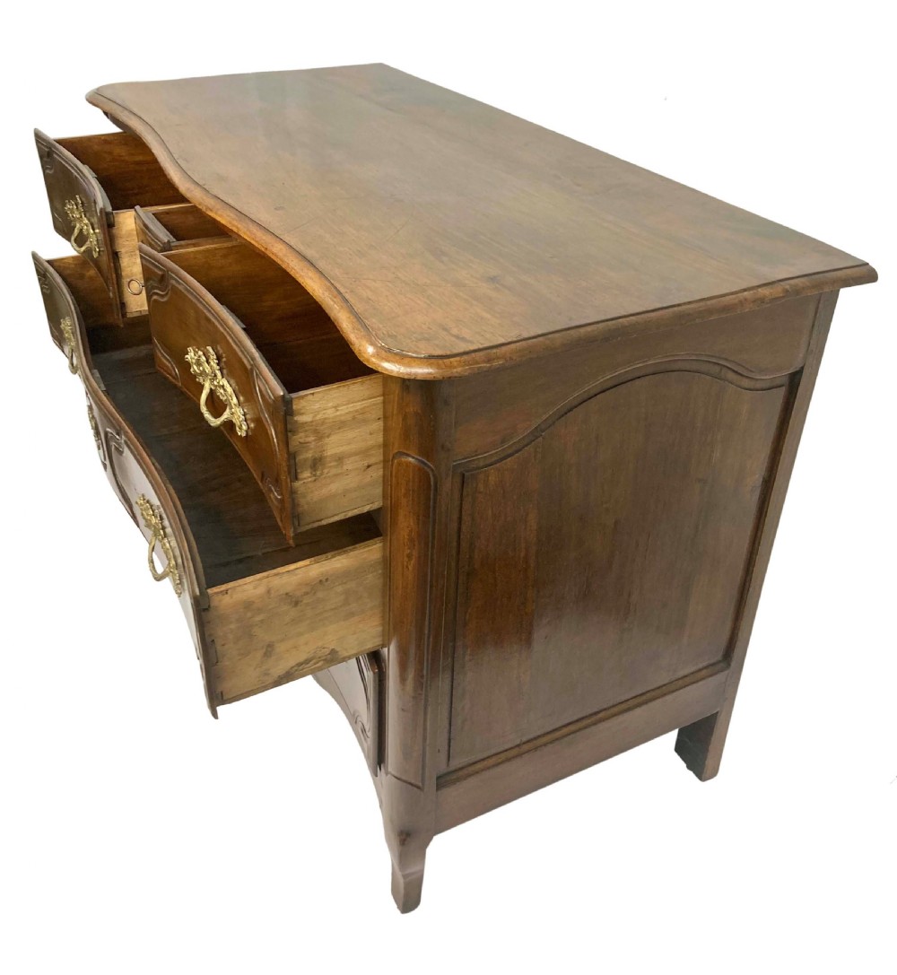 A French provincial walnut commode featuring three carved drawers with rococo brass handles and short cabriole legs. View V
