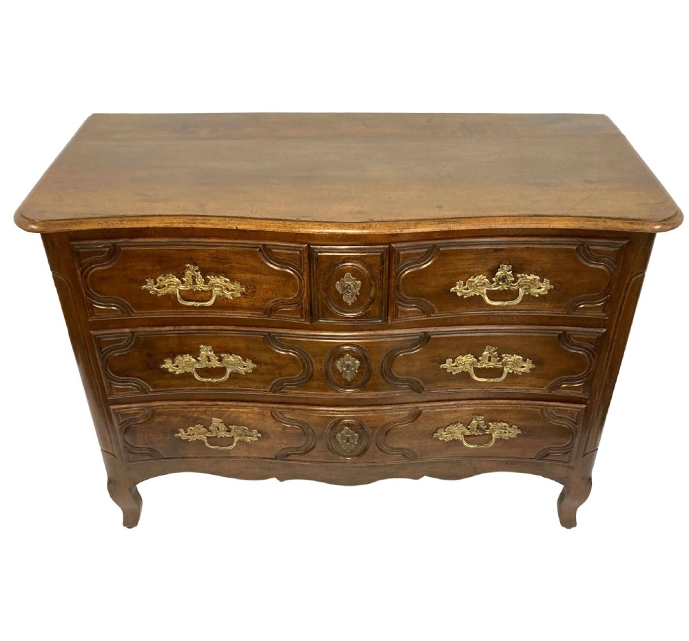 A French provincial walnut commode featuring three carved drawers with rococo brass handles and short cabriole legs. View VI