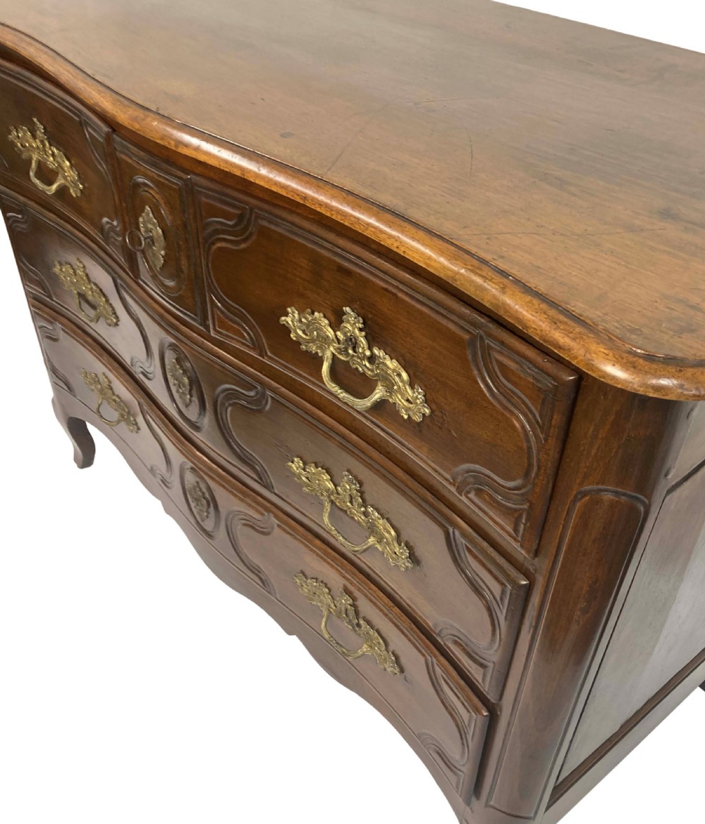 A French provincial walnut commode featuring three carved drawers with rococo brass handles and short cabriole legs. View VIII