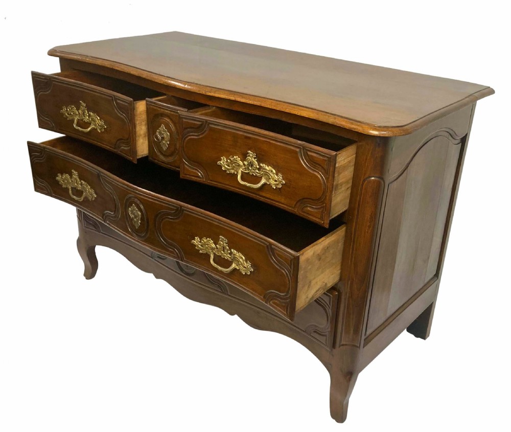 A French provincial walnut commode featuring three carved drawers with rococo brass handles and short cabriole legs. View IX