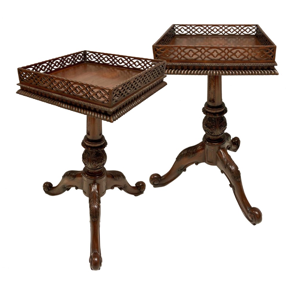 A pair of mahogany wine tables with square pierced fretwork galleries, carved central pedestals, and carved tripod cabriole legs.