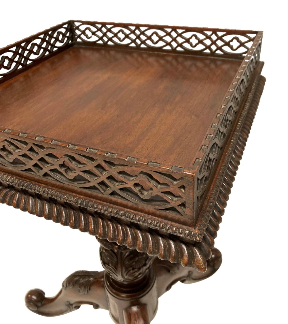 A pair of mahogany wine tables with square pierced fretwork galleries, carved central pedestals, and carved tripod cabriole legs. View V