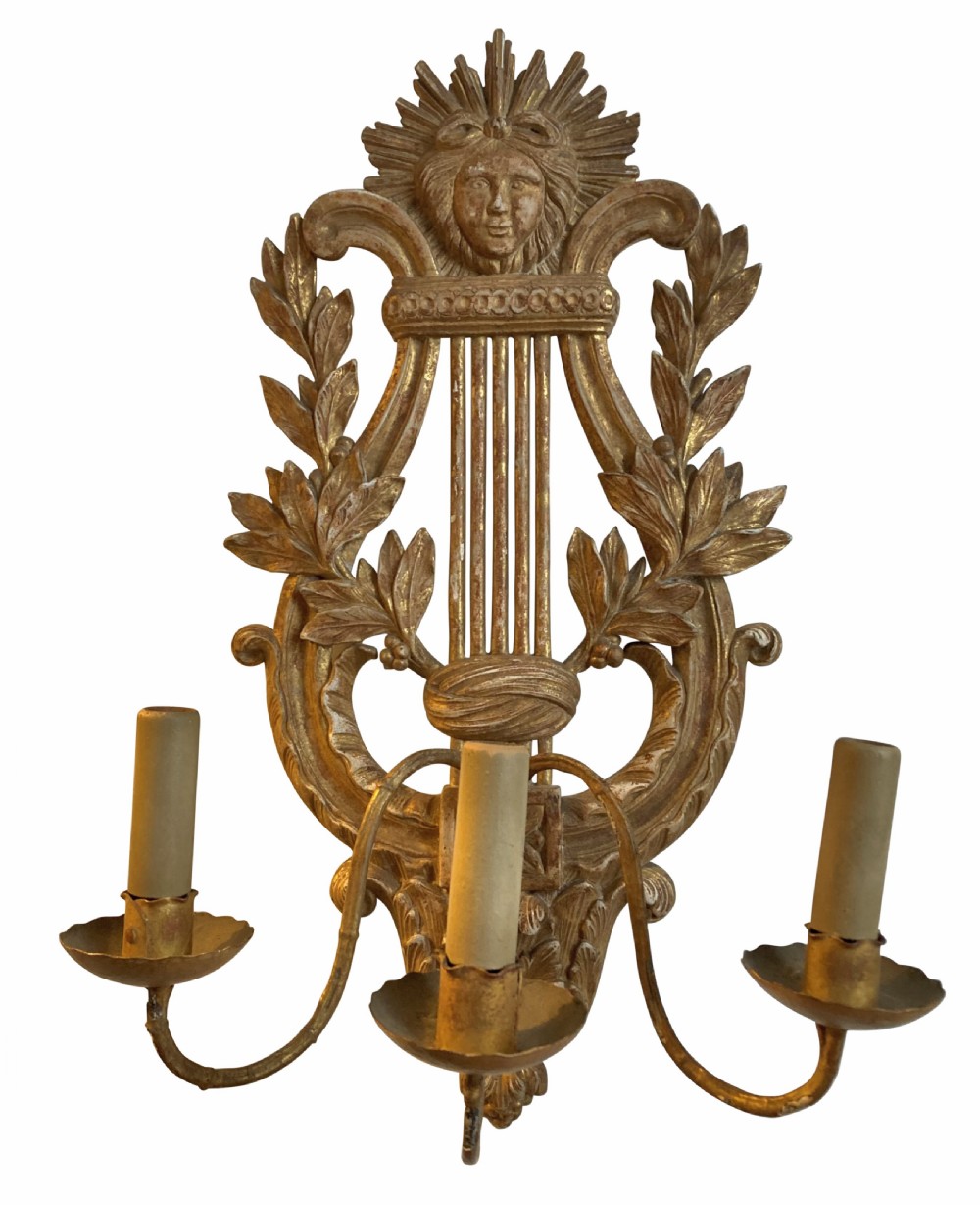 A pair of carved French giltwood wall sconces crafted in the shape of a musical lyre, featuring an Apollo sunburst mask top and three scrolling candle branches. View II