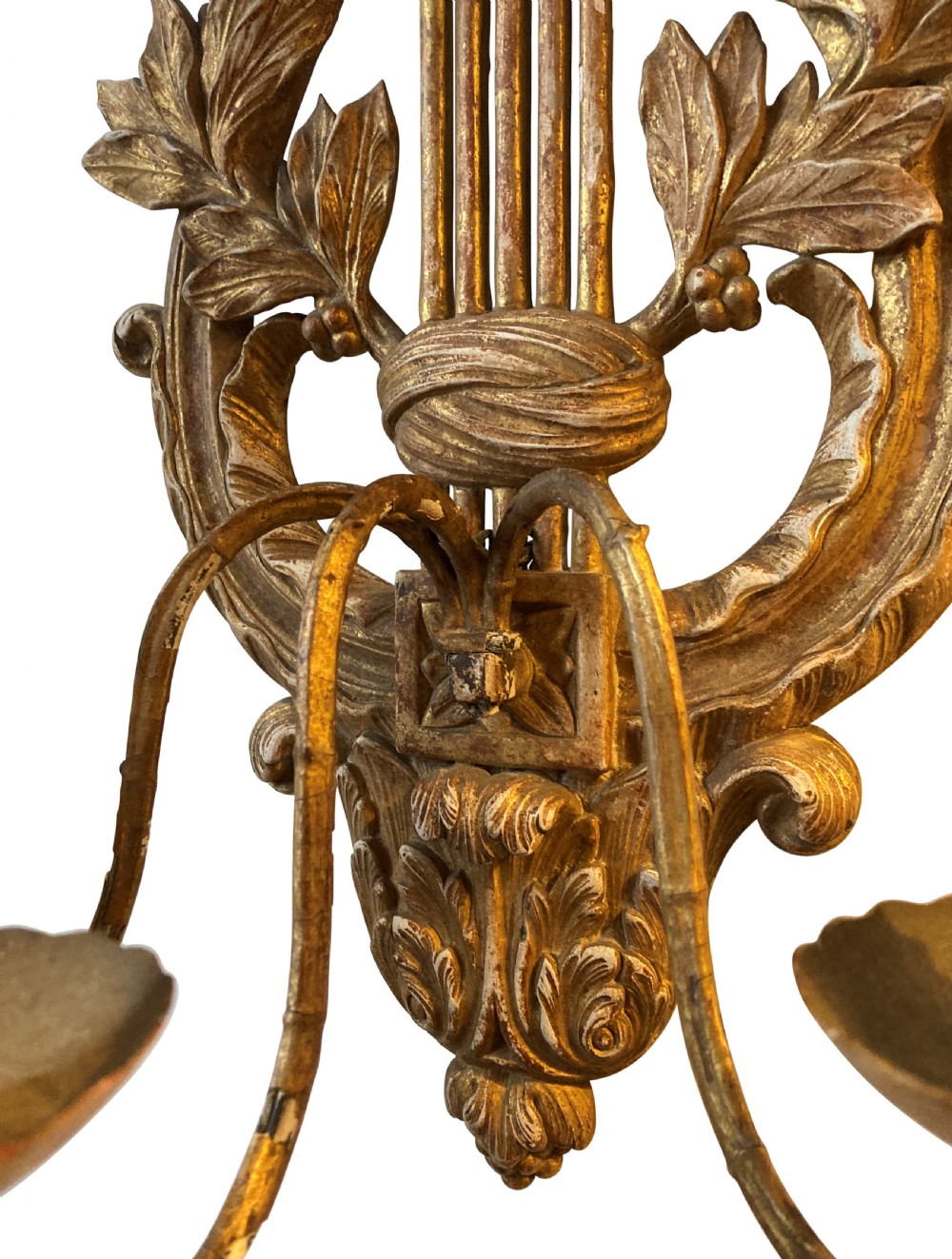 A pair of carved French giltwood wall sconces crafted in the shape of a musical lyre, featuring an Apollo sunburst mask top and three scrolling candle branches. View IV