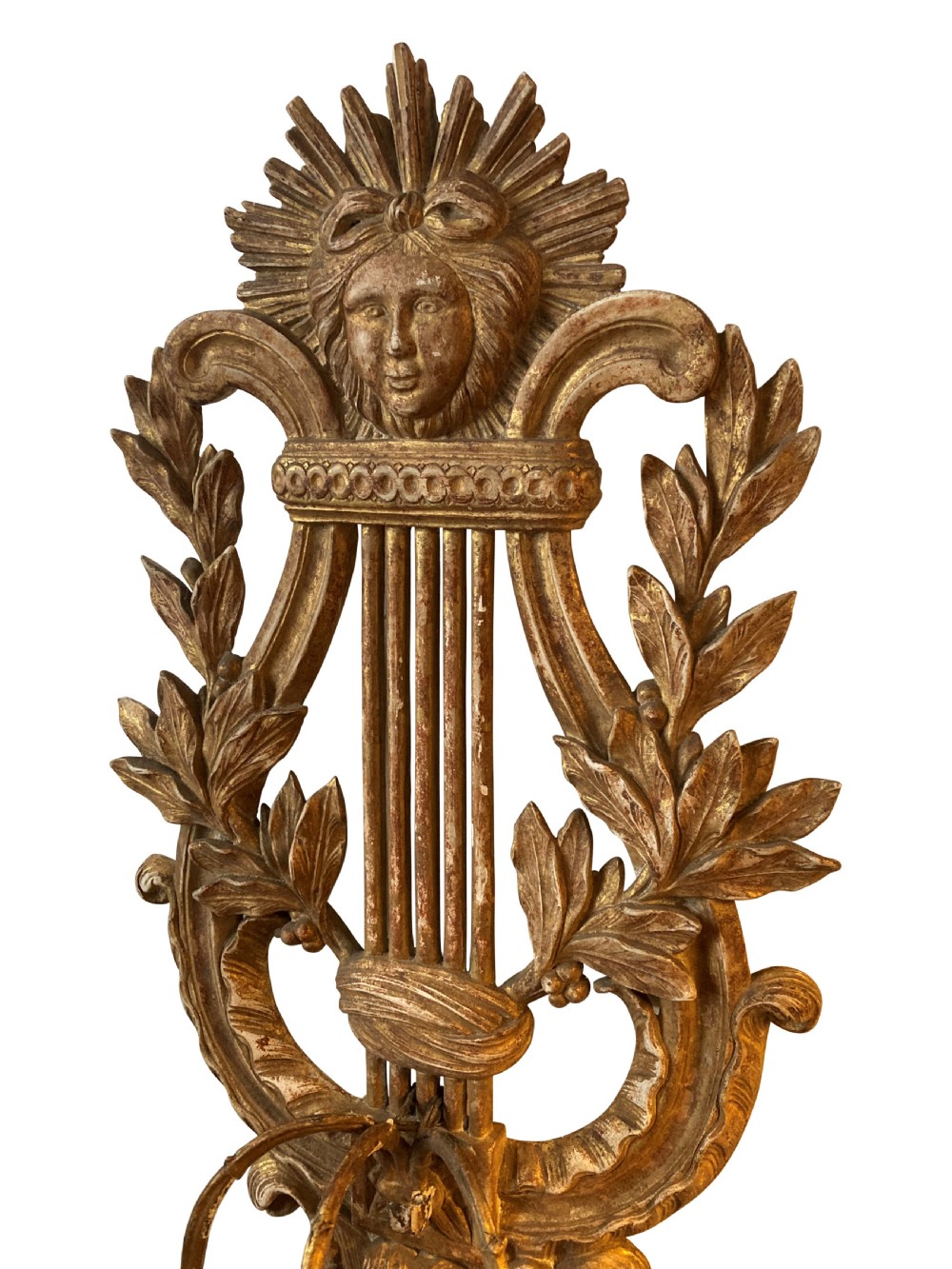 A pair of carved French giltwood wall sconces crafted in the shape of a musical lyre, featuring an Apollo sunburst mask top and three scrolling candle branches. View VI